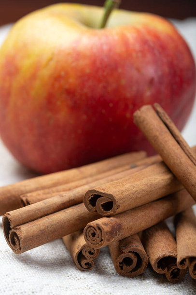Ingrediente de alimentos de pastelería de invierno, palitos de canela aromática seca y manzana en el plato de estaño de cerca
 - Foto, imagen