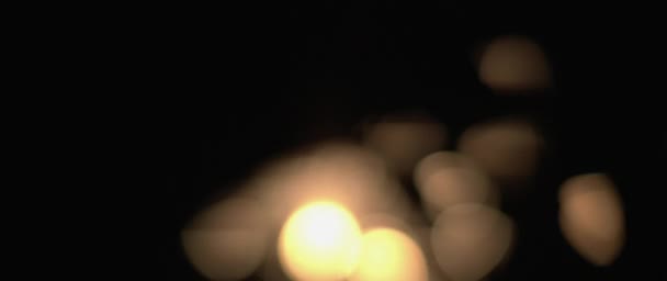 Abstrakcyjny rozmyty bokeh iskry płonącej w ciemności. Święta, świętowanie, Nowy Rok, Boże Narodzenie, koncepcja urodzin. Płytki DOF, zbliżenie, BMPCC 4K - Materiał filmowy, wideo