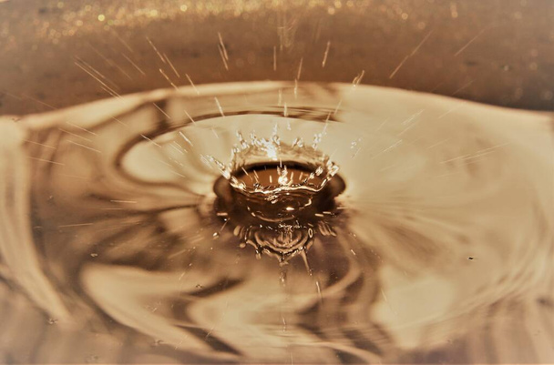 Крупным планом брызг золотой воды
 - Фото, изображение