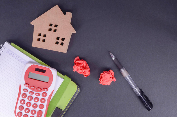 Building, mortgage, real estate and property concept - Top view of home model, calculator and notebook with pen. Selective focus. - Photo, Image