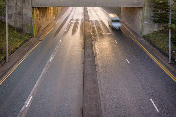 Перевищення швидкості фургона на порожній дорозі, що проходить під мостом
 - Фото, зображення