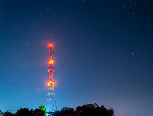 rádiótorony éjszakai csillagos ég háttér, piros lámpák, hosszú expozíció - Fotó, kép