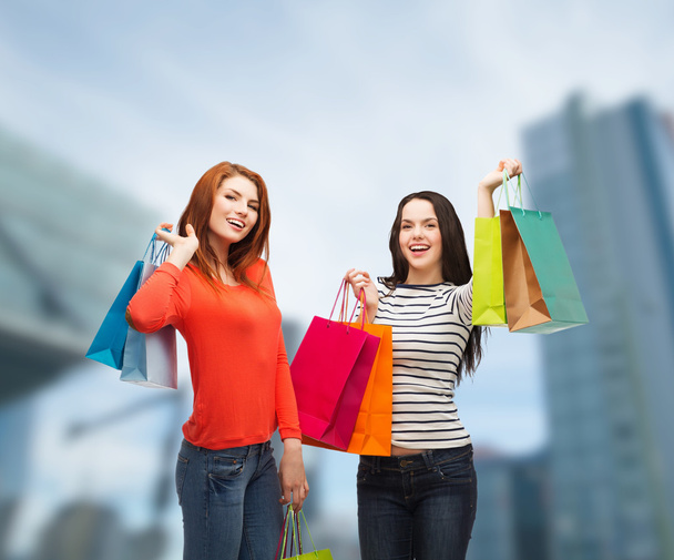 Two smiling teenage girls with shopping bags - Valokuva, kuva
