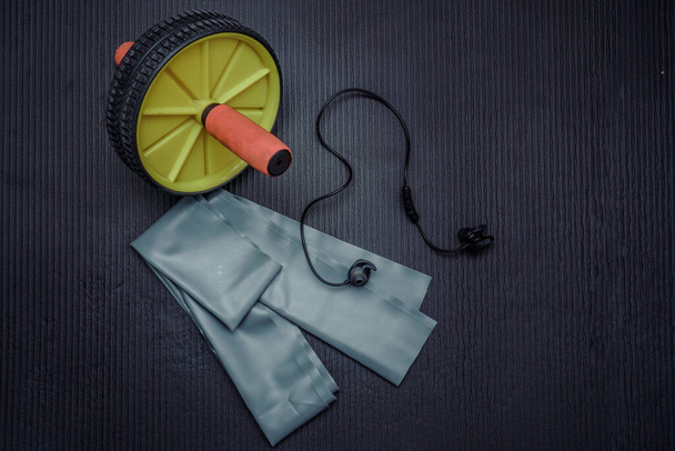 Home fitness yoga mat and abdominal wheel. Yoga mats and abdominal wheels in the gym. - Photo, Image