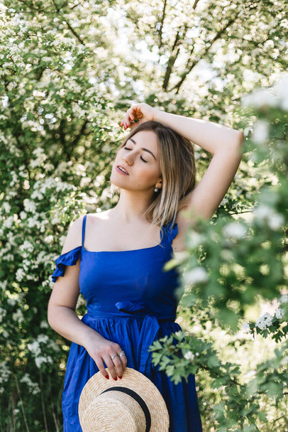 Retrato calmo sensual de mulher hipster bonita em arbusto florescente com flores brancas de spirea
. - Foto, Imagem