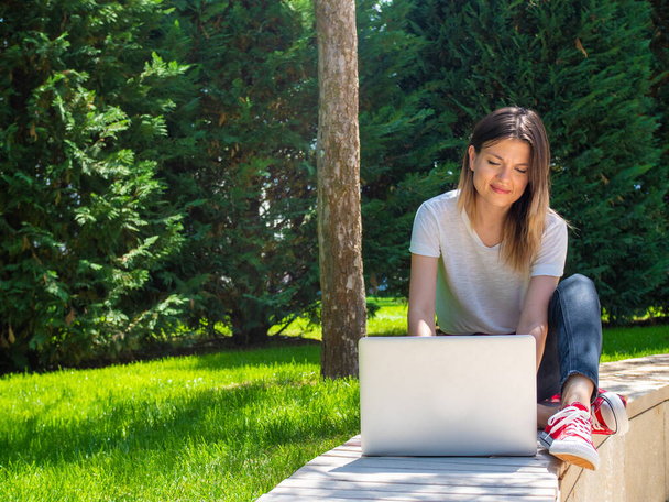 Дистанционное обучение онлайн. Женщина с ноутбуком на улице. Стартап бизнес
 - Фото, изображение