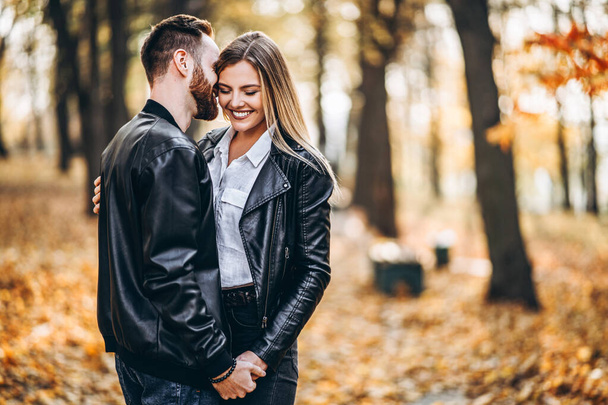 Portrait of a young loving couple. Man and woman hugging and smiling in the background of autumn park. - Fotografie, Obrázek