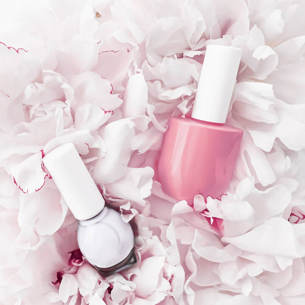 Nail polish bottles on floral background, french manicure and cosmetic branding - Zdjęcie, obraz