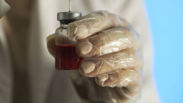 Encher o medicamento da ampola para a seringa um medicamento vermelho
 - Foto, Imagem