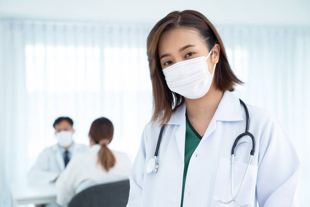アジアの女性医師は入院中に外科用マスクを着用する - 写真・画像