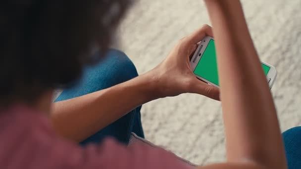 4K Teini-ikäinen poika ilmentää negatiivista reaktiota katsellessaan jotain puhelimellaan vihreällä näytöllä - Materiaali, video