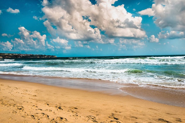 Zeegezicht bewolkt tafereel. Tropisch landschap met zand, golven van zee of oceaan. kalm paradijs, ontspanning, met een plons water en blauwe lucht landschap, Verbazingwekkende dramatische natuur achtergrond van strand en zee kust voor de zomer en reizen vakantie behang - Foto, afbeelding