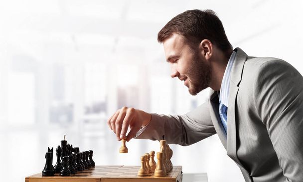 Επιχειρηματίας κινείται σκακιστική φιγούρα σε σκακιέρα - Φωτογραφία, εικόνα