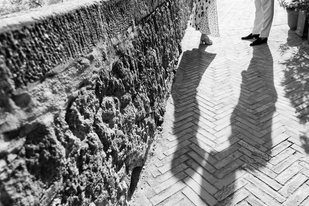 Schatten eines Hochzeitspaares auf dem Kopfsteinpflaster. Sie küssen sich - Foto, Bild