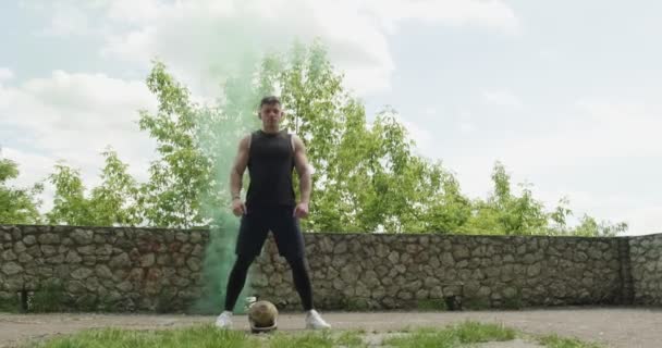 Training with kettlebells, intense strength exercise outdoor with smoke background. Men stay with kettlebell - Záběry, video