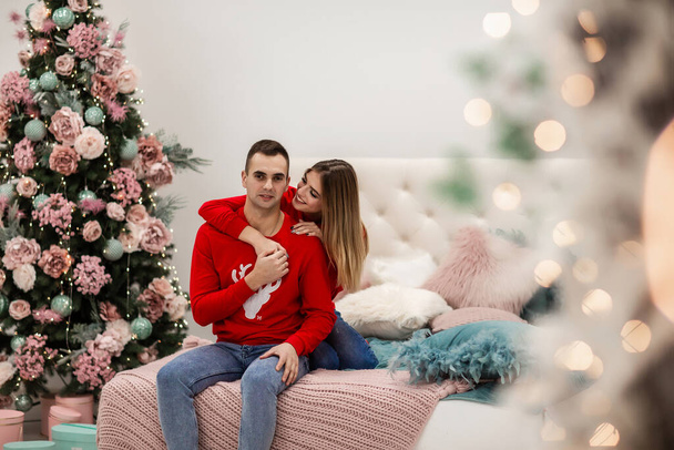 A loving couple enjoy each other on New Year's Eve. New Year's love story. A guy with a girl is celebrating Christmas. - Photo, Image