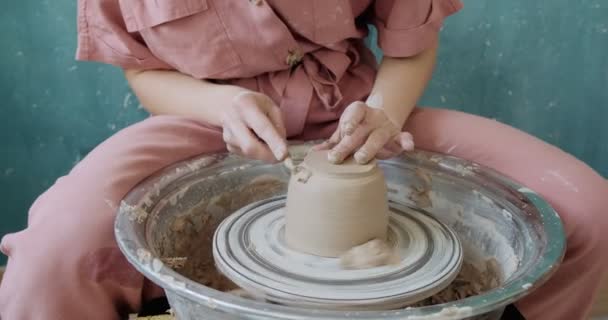 Töpferin sitzt und macht eine Tasse auf der Töpferscheibe. Frau, die Keramik herstellt. Töpfern, handwerkliches und kreatives Geschick - Filmmaterial, Video