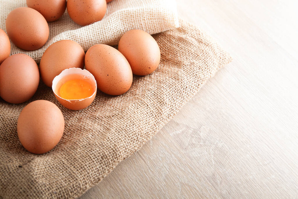 Wiele organicznych jaj kurzych umieszczane są na brązowej tkaninie i jest żółtko w środku. Jest to pożywienie, które jest korzystne dla organizmu. przestrzeń kopiowania - Zdjęcie, obraz
