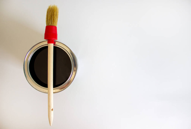A round paint brush lies on a can of paint on a white background. Copy space. - Valokuva, kuva