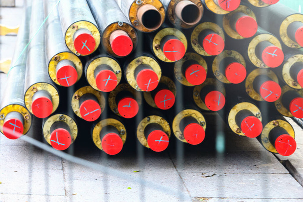 tubos subterrâneos deitado na calçada atrás de cerca de arame bares fundo abstrato
 - Foto, Imagem