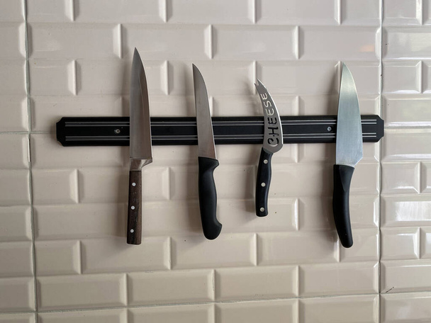 Conjuntos de cuchillos colgados en la pared
 - Foto, Imagen