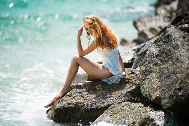Hermosa pelirroja en el mar. Mujer sensual. Hermosa mujer joven relajándose en la playa
. - Foto, Imagen