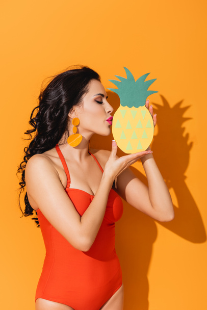oldalnézetben vonzó nő fürdőruhában csók papír vágott ananász narancs  - Fotó, kép