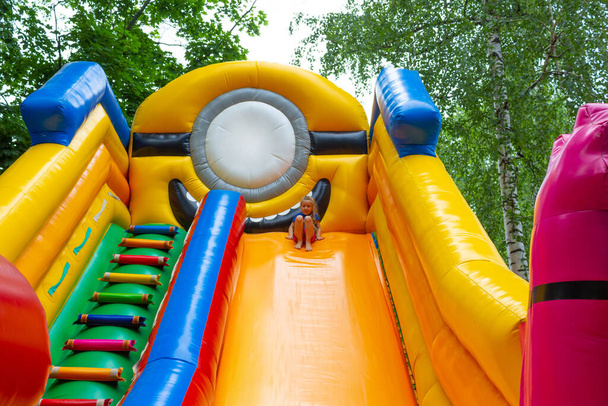 Image de fille joyeuse sur un grand trampoline gonflable en été. - Photo, image