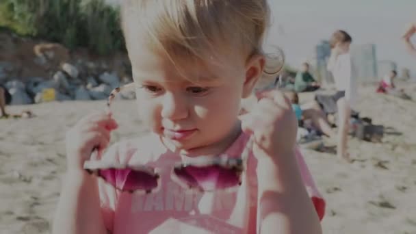 Chica joven con gafas de sol grandes en la playa
 - Metraje, vídeo