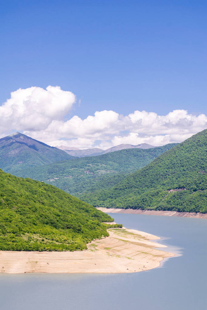Image verticale de l'espace vide du réservoir de Zhinvali par une journée ensoleillée avec des montagnes verdoyantes à l'arrière-plan et des nuages. Approvisionnement en eau en Géorgie.2020 - Photo, image
