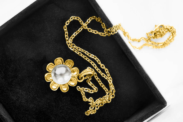 Vintage gold necklace with flower shaped pearl pendant in black jewel box - Фото, изображение