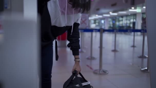 Mujer asiática pasajero check her baggage at check in counter, mujer asiática viajero lift heavy big bag luggage, journey during covid-19 world pandemic outbreak, new normal, safe journey travel alone - Metraje, vídeo