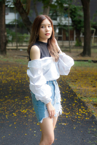 Portrait de thai Jeans jupe chemise blanche adulte belle fille se détendre et sourire
 - Photo, image