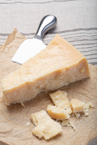 Συλλογή τυριών, Κομμάτι ιταλικού παλαιωμένου τυριού παρμεζάνας και μαχαίρι τυριού close up - Φωτογραφία, εικόνα
