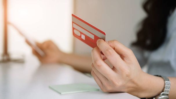 Cerca de la mujer que utiliza la tarjeta de crédito para comprar y comprar en línea en el teléfono móvil
 - Foto, Imagen