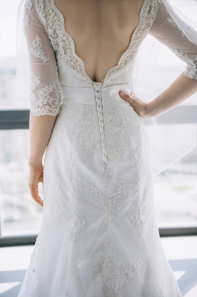 Невеста в белом платье стоит в стороне. Плата за невесту
 - Фото, изображение