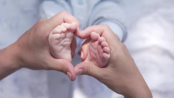 Naisten kädet tekevät sydämen ulos babys jalat - Materiaali, video
