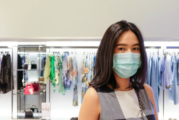 Adult Asian women wearing surgical face mask shopping in department store. New normal, new behavior lifestyle that we need to protect our health from Corona virus. Stay safe and Social distance. - Foto, Bild