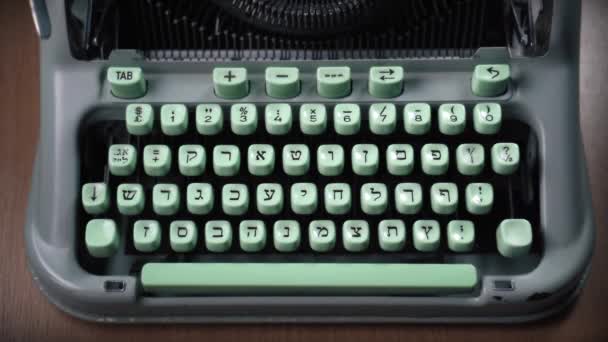 Mãos femininas digitando texto em uma velha máquina de escrever hebraica
 - Filmagem, Vídeo