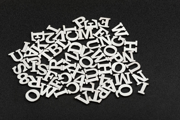Letras del alfabeto latino dispuestas en orden caótico. Fondo negro
 - Foto, imagen