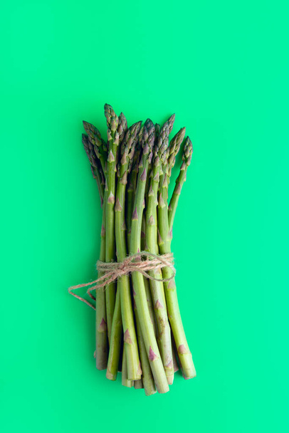 asparagus on a plain green background. view from above. color background. vertical orientation. - Foto, immagini