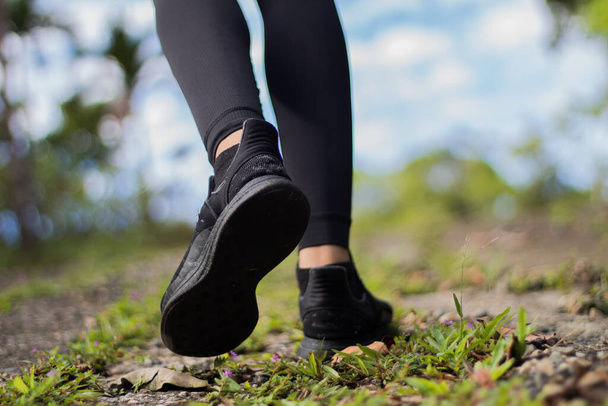 feet in black shoes walking on a hill - Φωτογραφία, εικόνα