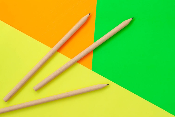 Kolme yksinkertaista kynää kirkkaan monivärinen tausta, tasainen lay. Takaisin kouluun ja koulutukseen käsite - Valokuva, kuva