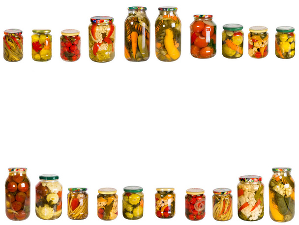 Рамка з різних скляних банок з консервованими овочами на білому тлі. Саморобні консерви для овочів
. - Фото, зображення