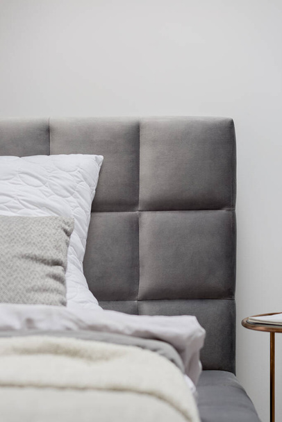 Close-up on gray and quilted headboard of comfortable bed - Valokuva, kuva
