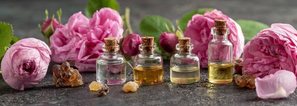 Cabecera panorámica de botellas de aceite esencial, incienso y flores rosa de mai
 - Foto, Imagen