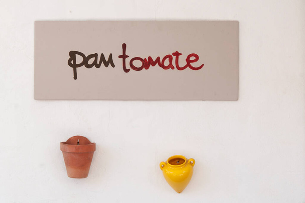 Fa asztal lóg legalább írott TOMATO BREAD. Fehér fal háttér akasztás kézzel készített terrakotta edények - Fotó, kép