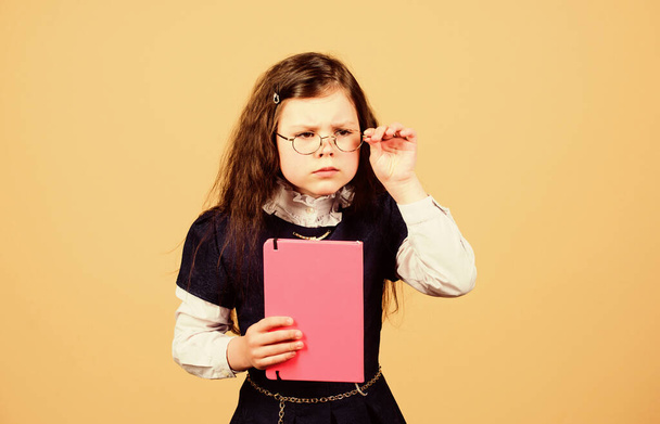 serious small girl wants to be teacher. notebook for diary notes. study lesson. knowledge and education. Back to school. hometwork. small girl with paper folder. School curriculum - Photo, image