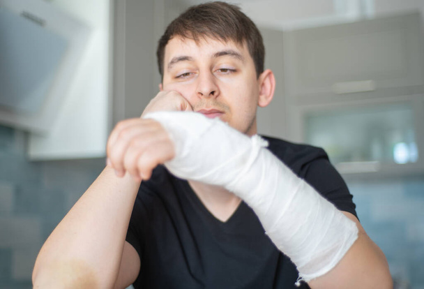 Fracture arm. Health restrictions. Sad man with a broken hand - Fotó, kép