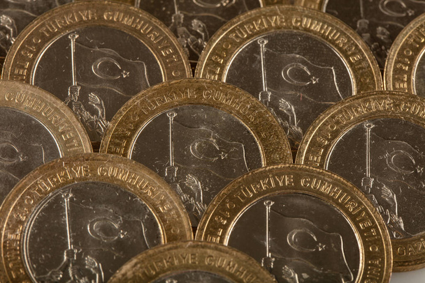 Jedno zbliżenie tureckiej liry na białym tle. Stos monet tureckich, jedna lira wersja specjalna. - Zdjęcie, obraz